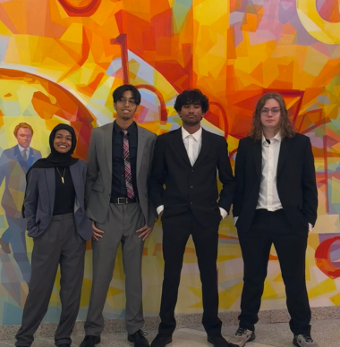  World Affairs students pose in front of a colorfullly painted wall